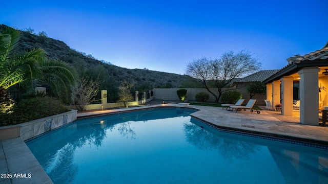 view of swimming pool with a fenced in pool, a fenced backyard, a mountain view, and a patio