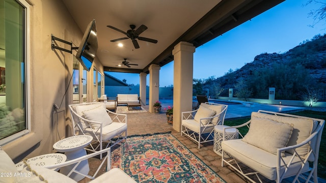 view of patio featuring a pool, outdoor lounge area, and a ceiling fan