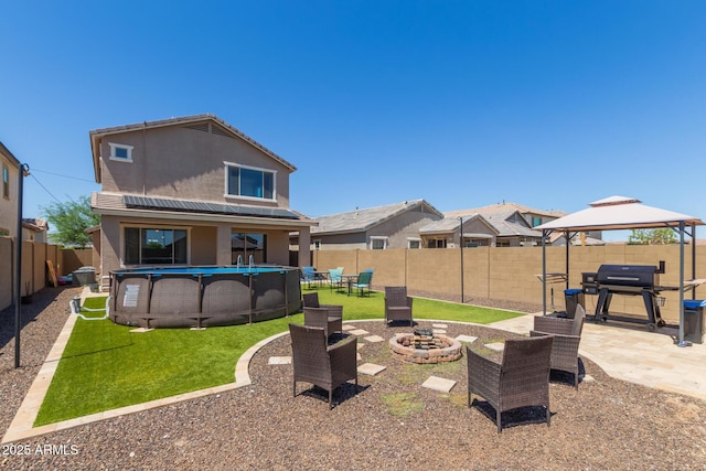 19771 W Woodlands Ave, Buckeye, AZ 85326 - rear view of property with stucco siding, a gazebo, a fenced backyard, a fire pit, and a patio