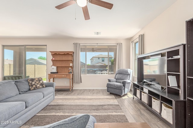 19771 W Woodlands Ave, Buckeye, AZ 85326 - living room with wood finished floors, ceiling fan, and plenty of natural light