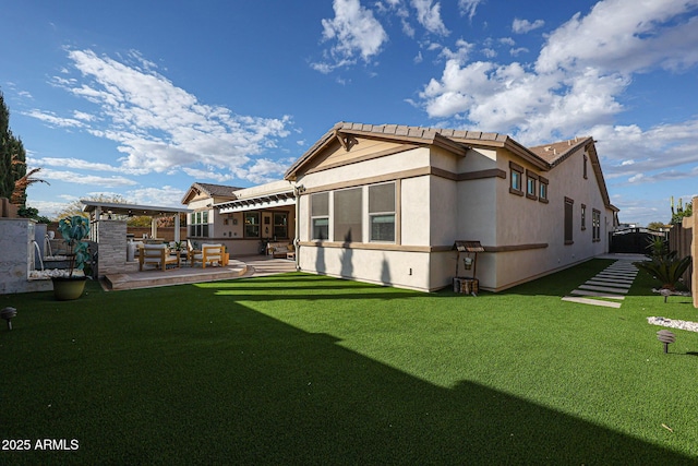 back of house with a lawn, fence, stucco siding, and a patio area