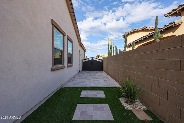 view of yard with a gate, a patio area, and a fenced backyard