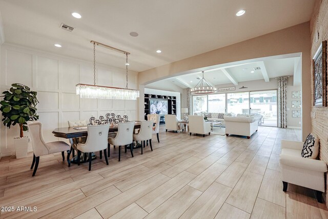 dining space with visible vents, vaulted ceiling with beams, an inviting chandelier, arched walkways, and light wood-type flooring