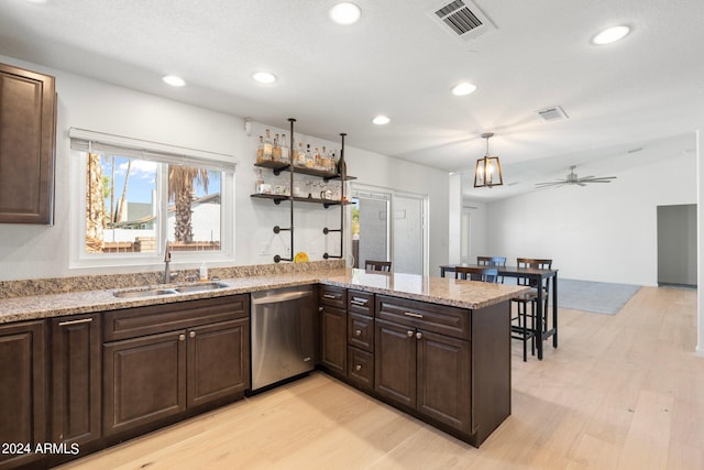 kitchen with light stone countertops, light hardwood / wood-style floors, sink, kitchen peninsula, and stainless steel dishwasher