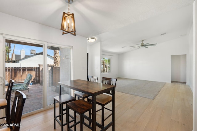 dining room featuring a textured ceiling, ceiling fan with notable chandelier, and light hardwood / wood-style floors