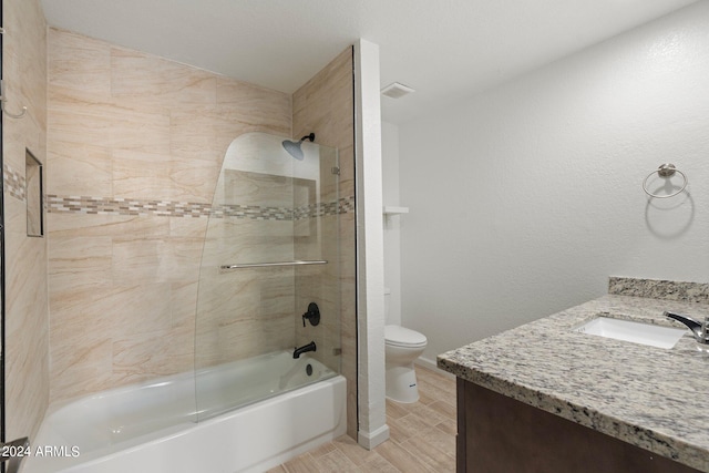 full bathroom featuring vanity, toilet, hardwood / wood-style flooring, and tiled shower / bath