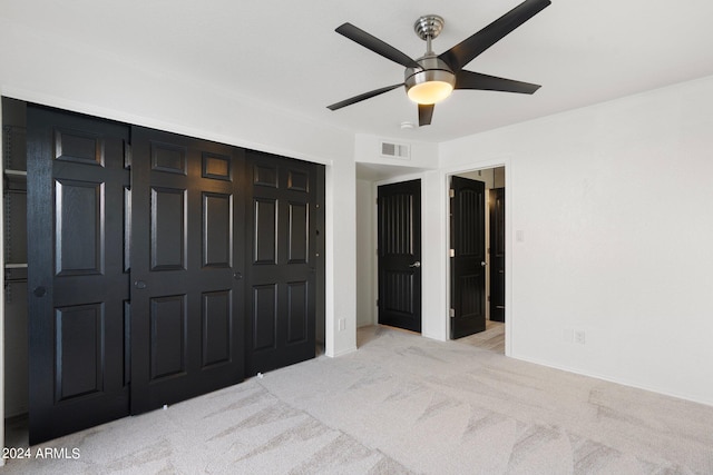 unfurnished bedroom featuring light carpet, ceiling fan, and a closet