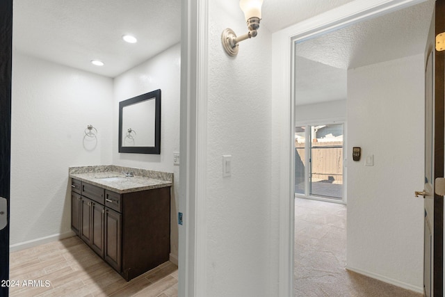 bathroom featuring vanity, a textured ceiling, and hardwood / wood-style flooring