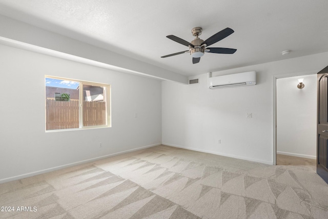 carpeted empty room featuring a wall unit AC and ceiling fan