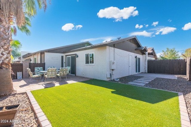 back of house with a yard and a patio