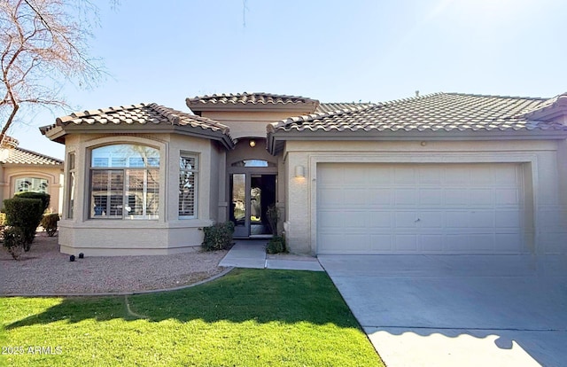 mediterranean / spanish-style house featuring a garage and a front yard