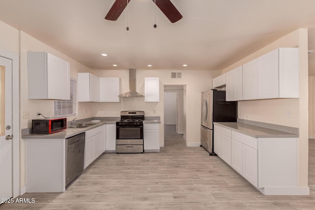 kitchen with wall chimney range hood, a ceiling fan, visible vents, stainless steel appliances, and recessed lighting