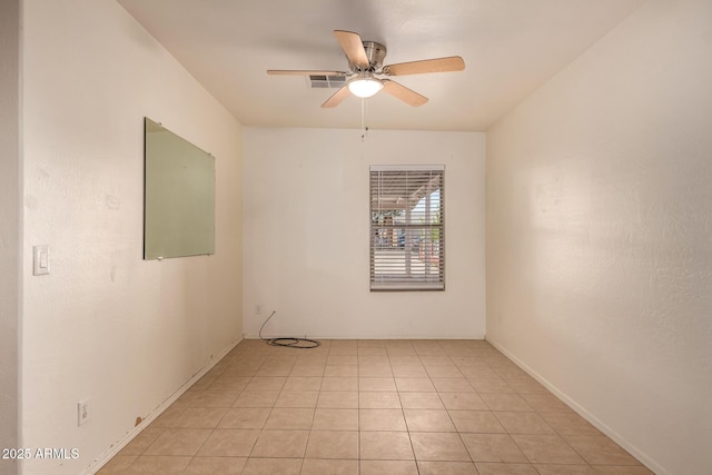 empty room with a ceiling fan and light tile patterned flooring