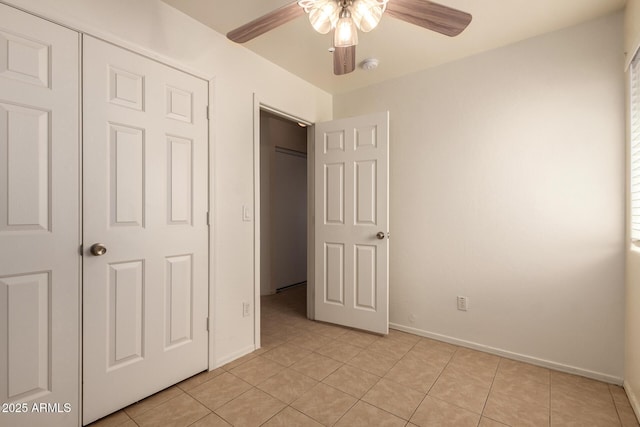 unfurnished bedroom featuring baseboards, ceiling fan, and light tile patterned flooring