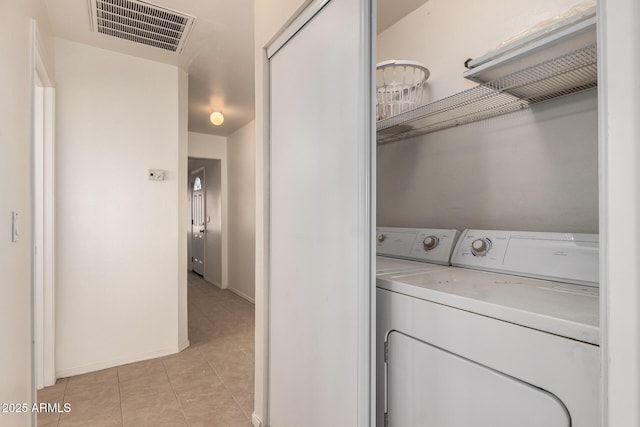 laundry area with light tile patterned floors, washer and dryer, and visible vents