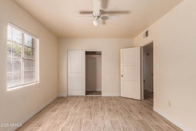 unfurnished bedroom with light wood-style floors, a ceiling fan, baseboards, visible vents, and a closet