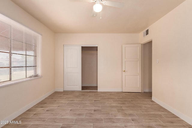 unfurnished bedroom featuring ceiling fan, visible vents, baseboards, a closet, and light wood finished floors