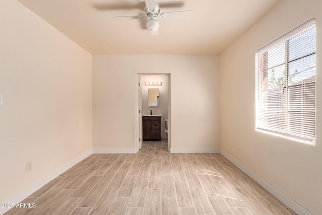 spare room with light wood-style floors, baseboards, and a ceiling fan