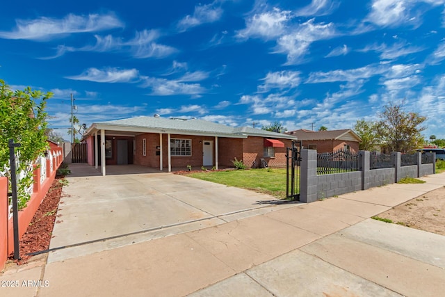 single story home featuring a front lawn, an attached carport, brick siding, a fenced front yard, and driveway