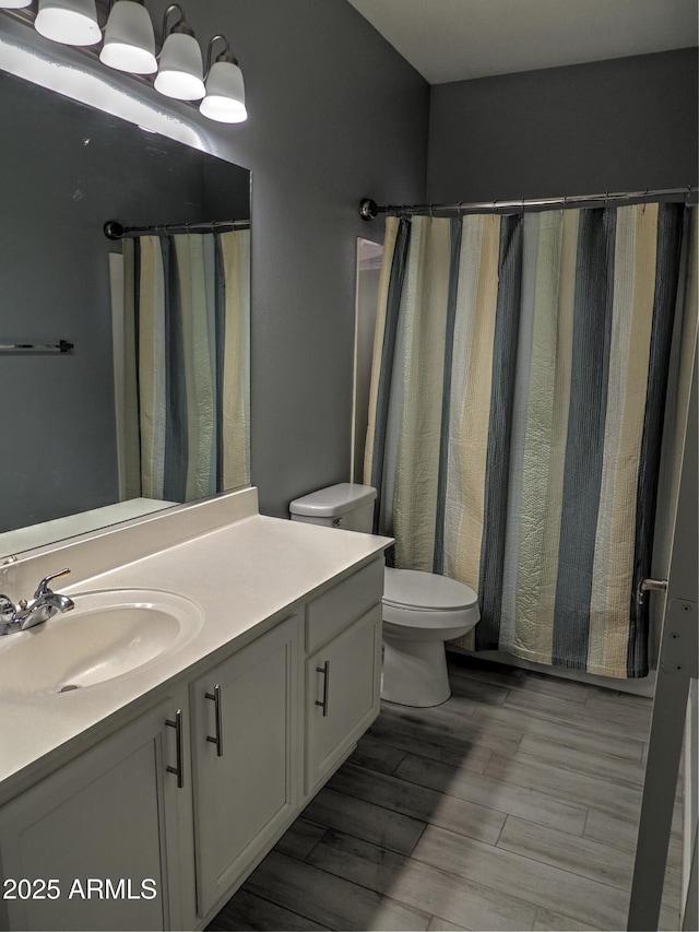 bathroom with vanity, wood-type flooring, and toilet