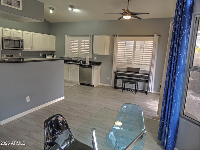 kitchen with sink, light hardwood / wood-style flooring, ceiling fan, stainless steel appliances, and white cabinets