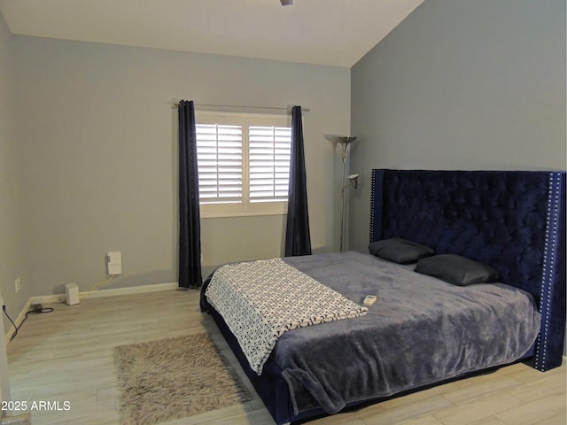 bedroom featuring lofted ceiling and light wood-type flooring