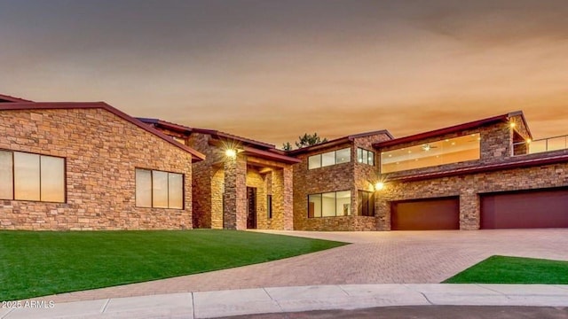 15217 N 15th Dr, Phoenix, AZ 85023 - view of front facade featuring stone siding, decorative driveway, an attached garage, and a lawn