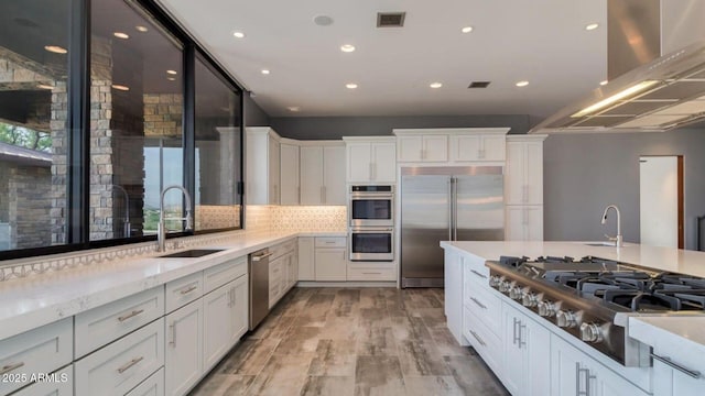 15217 N 15th Dr, Phoenix, AZ 85023 - kitchen featuring white cabinetry, wall chimney range hood, appliances with stainless steel finishes, and a sink