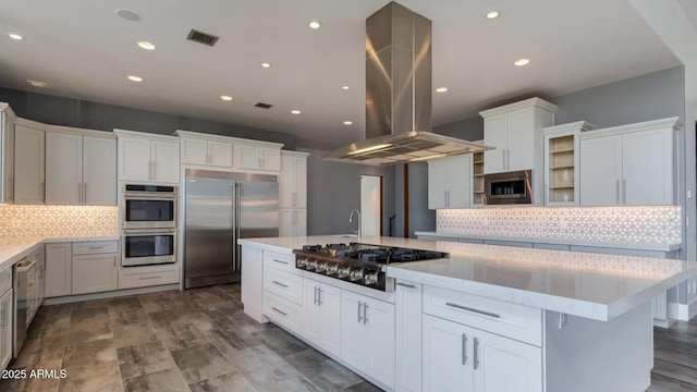 15217 N 15th Dr, Phoenix, AZ 85023 - kitchen with island exhaust hood, white cabinetry, built in appliances, light countertops, and tasteful backsplash