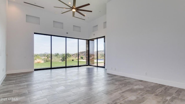 15217 N 15th Dr, Phoenix, AZ 85023 - unfurnished room with baseboards, ceiling fan, and a high ceiling