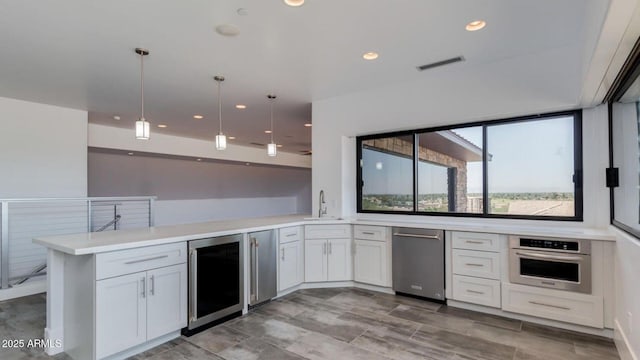 15217 N 15th Dr, Phoenix, AZ 85023 - kitchen with a sink, a peninsula, stainless steel appliances, beverage cooler, and white cabinets