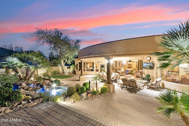 exterior space featuring ceiling fan, a patio, an outdoor hangout area, fence, and stucco siding