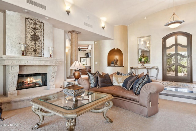 living room featuring high vaulted ceiling, decorative columns, visible vents, and a high end fireplace