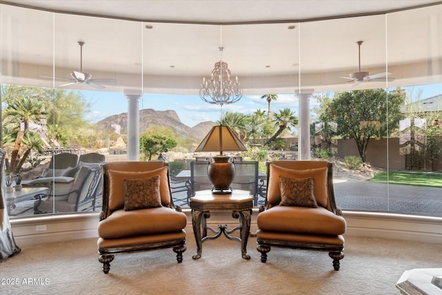 sunroom featuring ceiling fan, a mountain view, and a wealth of natural light