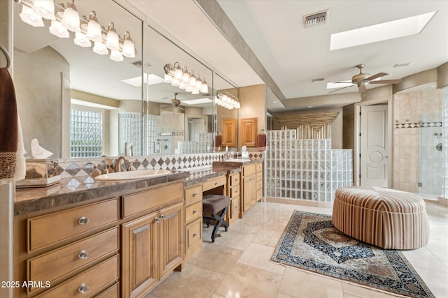 bathroom with a stall shower, visible vents, vanity, and a skylight