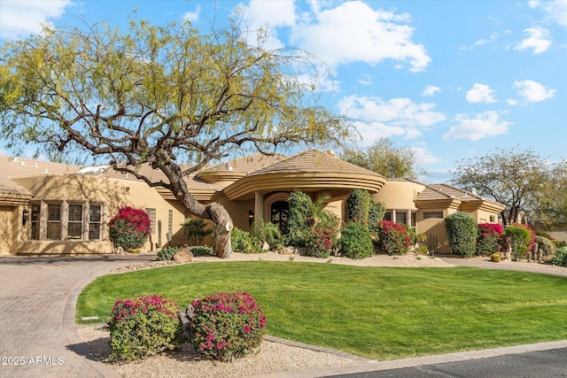 view of front of home featuring a front yard, driveway, and stucco siding