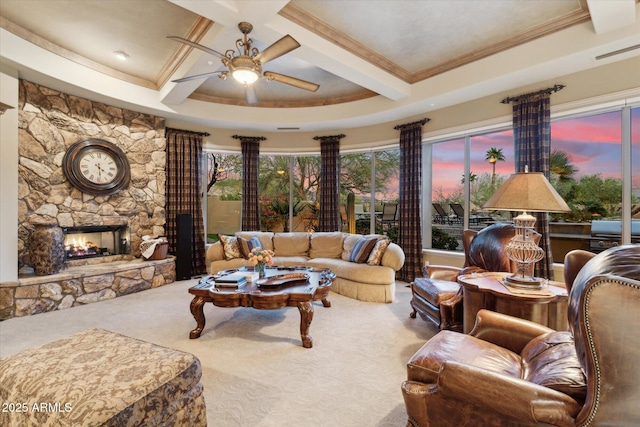 living room with a stone fireplace, coffered ceiling, carpet flooring, a ceiling fan, and beamed ceiling