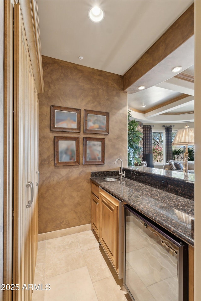 bar with light tile patterned floors, beverage cooler, a sink, beam ceiling, and indoor wet bar