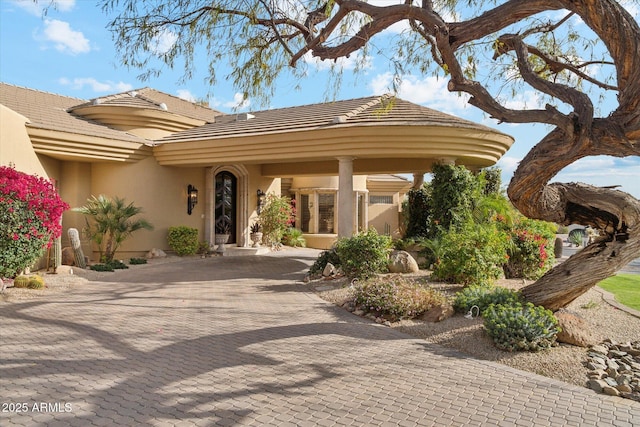 exterior space with decorative driveway and stucco siding