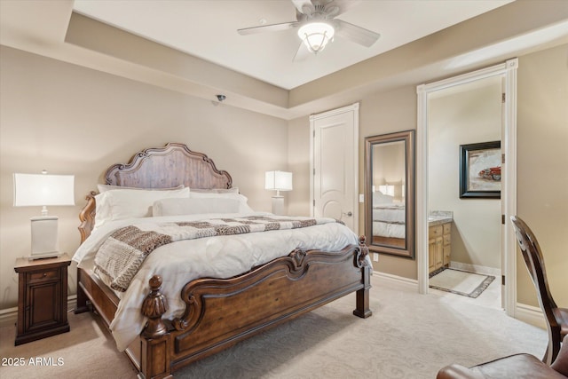 bedroom featuring a ceiling fan, light carpet, baseboards, and ensuite bathroom