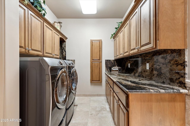 washroom featuring cabinet space, baseboards, and separate washer and dryer