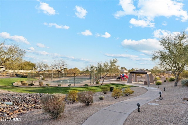 view of property's community featuring a tennis court, fence, and a gazebo