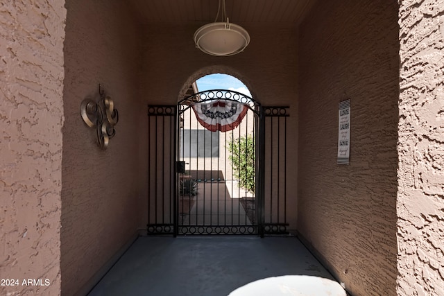 doorway to property with stucco siding and a gate