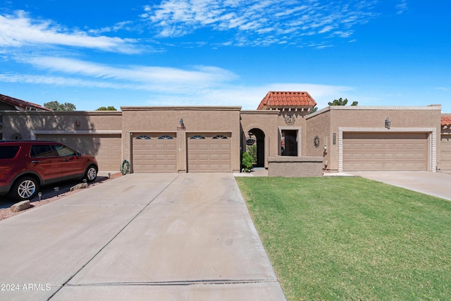 mediterranean / spanish home featuring concrete driveway, stucco siding, a front yard, a garage, and a tiled roof