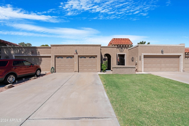 mediterranean / spanish-style house with stucco siding, concrete driveway, a front yard, an attached garage, and a tiled roof