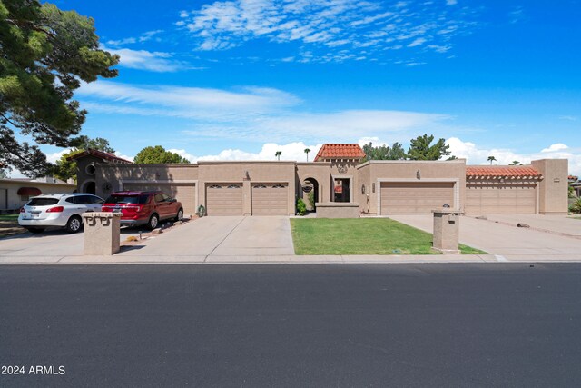 view of front of home with a tile roof, a garage, driveway, and stucco siding