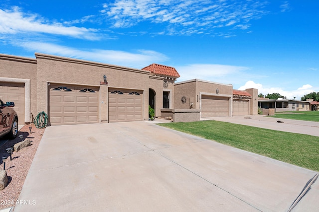 view of front facade featuring driveway, stucco siding, a front lawn, a garage, and a tiled roof