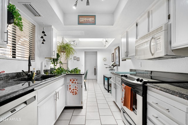 kitchen with white microwave, stainless steel electric stove, dishwasher, and a raised ceiling