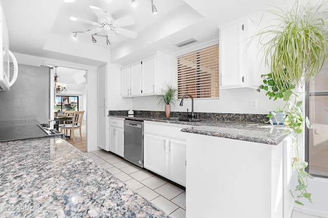 kitchen featuring stainless steel appliances, white cabinets, a sink, and a raised ceiling