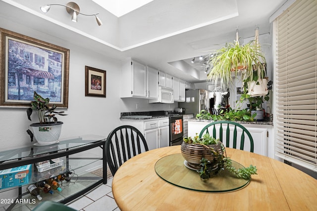 dining room with a skylight and a raised ceiling